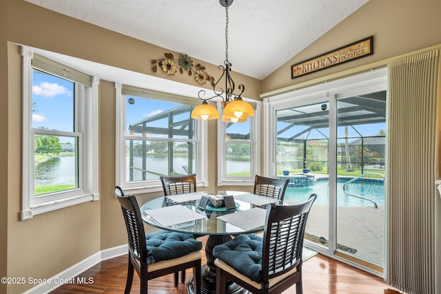 3360 Fort Sumter St, Melbourne, FL 32934 - dining area with a sunroom, lofted ceiling, wood finished floors, a chandelier, and baseboards