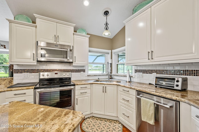 3360 Fort Sumter St, Melbourne, FL 32934 - kitchen featuring stainless steel appliances, a sink, lofted ceiling, white cabinets, and decorative backsplash