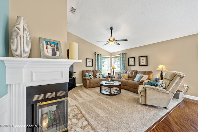3360 Fort Sumter St, Melbourne, FL 32934 - living area featuring a multi sided fireplace, ceiling fan, a textured ceiling, lofted ceiling, and baseboards