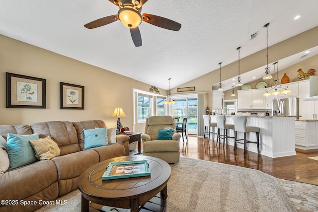 3360 Fort Sumter St, Melbourne, FL 32934 - living room featuring vaulted ceiling, a chandelier, wood finished floors, ceiling fan, and a textured ceiling