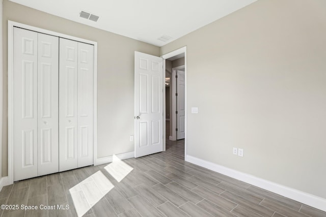 1342 Tordira St SE, Palm Bay, FL 32909 - unfurnished bedroom featuring baseboards, wood tiled floors, and a closet