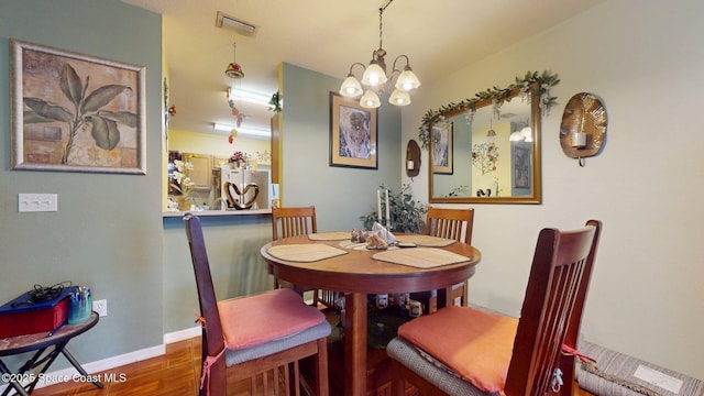 824 Temple St, Cocoa, FL 32922 - dining space featuring a chandelier, wood finished floors, and baseboards