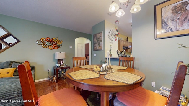 824 Temple St, Cocoa, FL 32922 - dining room featuring arched walkways, baseboards, and a chandelier