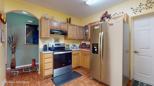 824 Temple St, Cocoa, FL 32922 - kitchen with appliances with stainless steel finishes, under cabinet range hood, light countertops, arched walkways, and baseboards