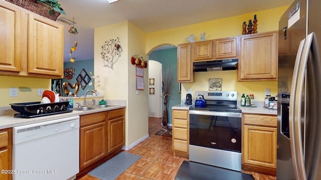 824 Temple St, Cocoa, FL 32922 - kitchen featuring appliances with stainless steel finishes, under cabinet range hood, a sink, arched walkways, and light countertops