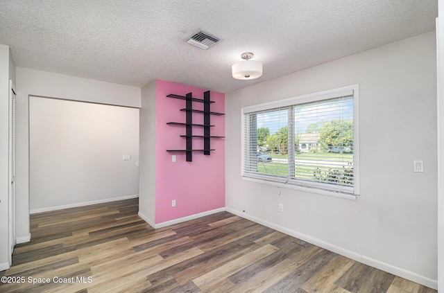 1573 Eagle Ave NW, Palm Bay, FL 32907 - unfurnished bedroom with wood finished floors, baseboards, and a textured ceiling