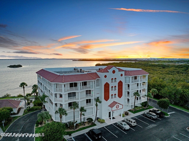 8984 Puerto Del Rio Dr Unit 202, Cape Canaveral, FL 32920 - view of building exterior with uncovered parking and a water view