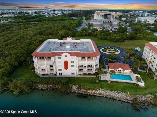 8984 Puerto Del Rio Dr Unit 202, Cape Canaveral, FL 32920 - aerial view at dusk of a water view and view of pool area