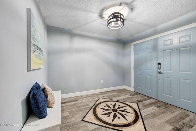 8984 Puerto Del Rio Dr Unit 202, Cape Canaveral, FL 32920 - entrance foyer featuring wood finished floors, a textured ceiling, and baseboards