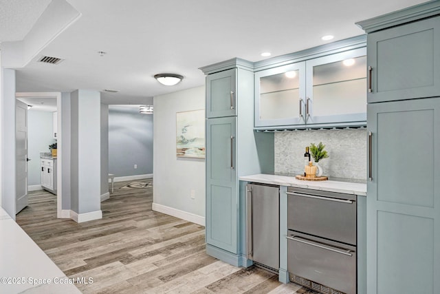 8984 Puerto Del Rio Dr Unit 202, Cape Canaveral, FL 32920 - bar area featuring light wood finished floors, baseboards, tasteful backsplash, freestanding refrigerator, and recessed lighting