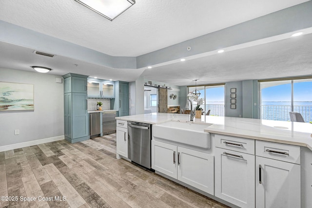 8984 Puerto Del Rio Dr Unit 202, Cape Canaveral, FL 32920 - kitchen featuring dishwasher, a sink, light wood-type flooring, baseboards, and a textured ceiling