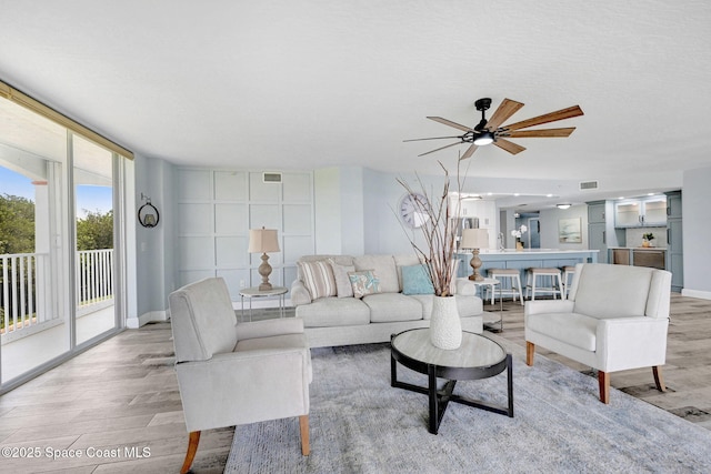8984 Puerto Del Rio Dr Unit 202, Cape Canaveral, FL 32920 - living area featuring light wood finished floors, ceiling fan, and baseboards