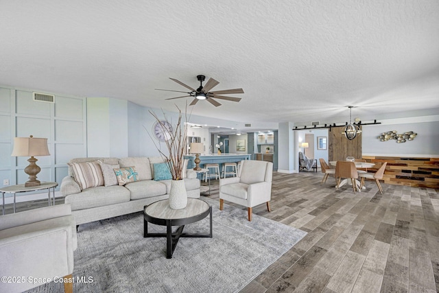 8984 Puerto Del Rio Dr Unit 202, Cape Canaveral, FL 32920 - living area with wood finished floors, a textured ceiling, a ceiling fan, and a chandelier