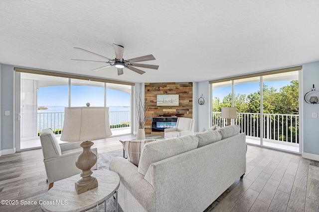 8984 Puerto Del Rio Dr Unit 202, Cape Canaveral, FL 32920 - living area featuring wood finished floors, baseboards, a ceiling fan, healthy amount of natural light, and a textured ceiling