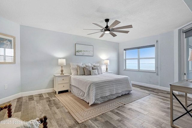 8984 Puerto Del Rio Dr Unit 202, Cape Canaveral, FL 32920 - bedroom with light wood finished floors, baseboards, and ceiling fan
