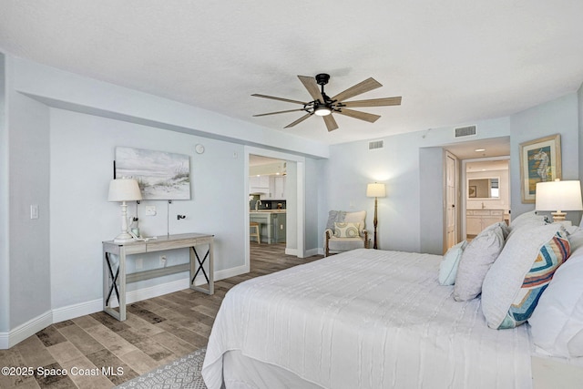 8984 Puerto Del Rio Dr Unit 202, Cape Canaveral, FL 32920 - bedroom with wood finished floors, ensuite bathroom, baseboards, and ceiling fan