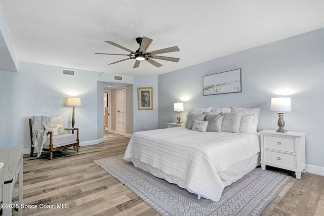 8984 Puerto Del Rio Dr Unit 202, Cape Canaveral, FL 32920 - bedroom featuring light wood-style flooring, baseboards, and a ceiling fan