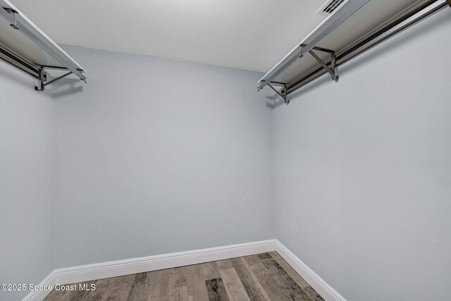 8984 Puerto Del Rio Dr Unit 202, Cape Canaveral, FL 32920 - walk in closet featuring wood finished floors