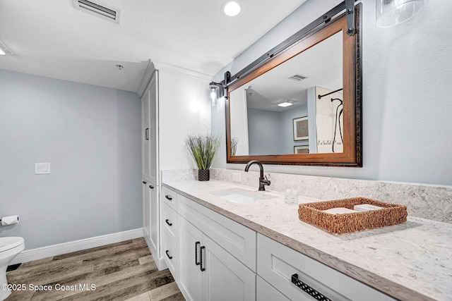 8984 Puerto Del Rio Dr Unit 202, Cape Canaveral, FL 32920 - full bath with vanity, wood finished floors, toilet, baseboards, and recessed lighting