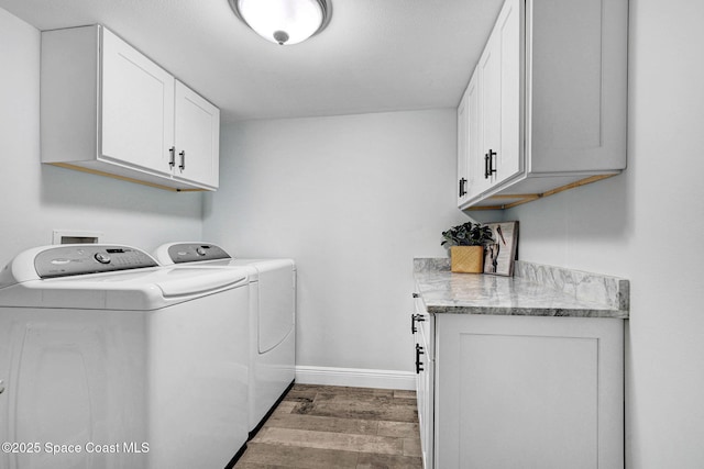 8984 Puerto Del Rio Dr Unit 202, Cape Canaveral, FL 32920 - washroom featuring cabinet space, washing machine and clothes dryer, wood finished floors, and baseboards
