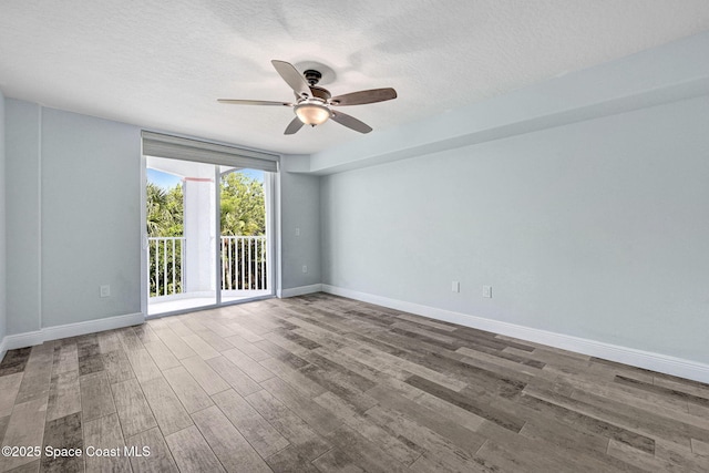 8984 Puerto Del Rio Dr Unit 202, Cape Canaveral, FL 32920 - empty room with wood finished floors, a ceiling fan, a textured ceiling, and baseboards