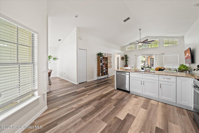 3046 Sebastian Ln, Melbourne, FL 32935 - kitchen with stainless steel dishwasher, a sink, a ceiling fan, vaulted ceiling, and white cabinets