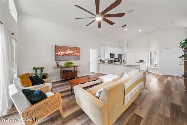 3046 Sebastian Ln, Melbourne, FL 32935 - living room featuring high vaulted ceiling, a ceiling fan, wood finished floors, and recessed lighting