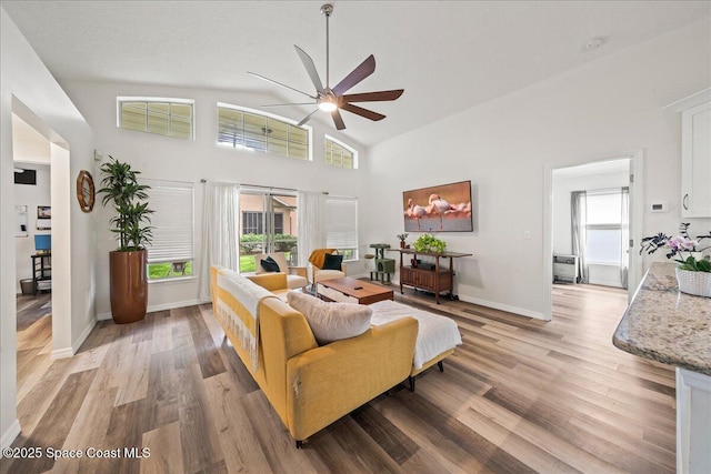 3046 Sebastian Ln, Melbourne, FL 32935 - living area with ceiling fan, light wood-style floors, high vaulted ceiling, and baseboards