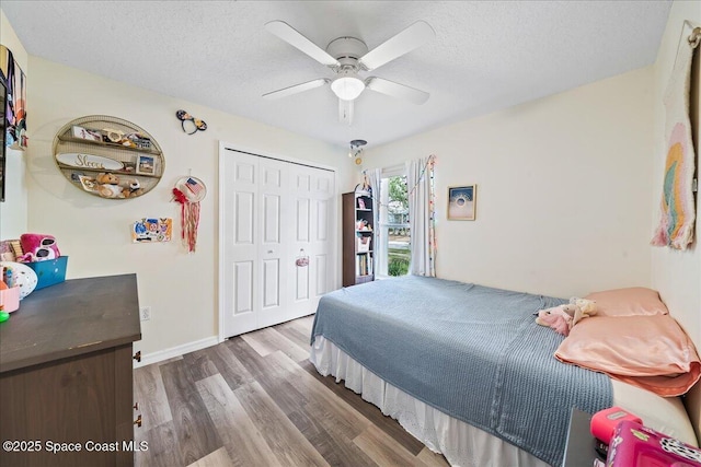 3046 Sebastian Ln, Melbourne, FL 32935 - bedroom featuring a textured ceiling, wood finished floors, a closet, and a ceiling fan