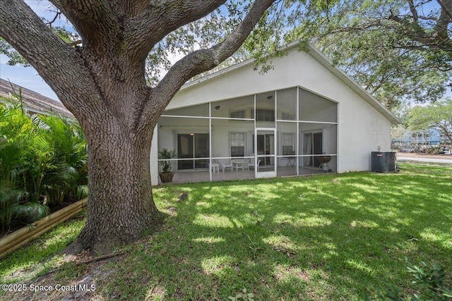 3046 Sebastian Ln, Melbourne, FL 32935 - rear view of property featuring a sunroom, central AC, stucco siding, and a lawn