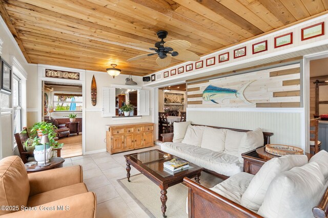 420 Tortoise View Cir, Satellite Beach, FL 32937 - living room featuring wood ceiling, ceiling fan, wainscoting, light tile patterned floors, and wood walls