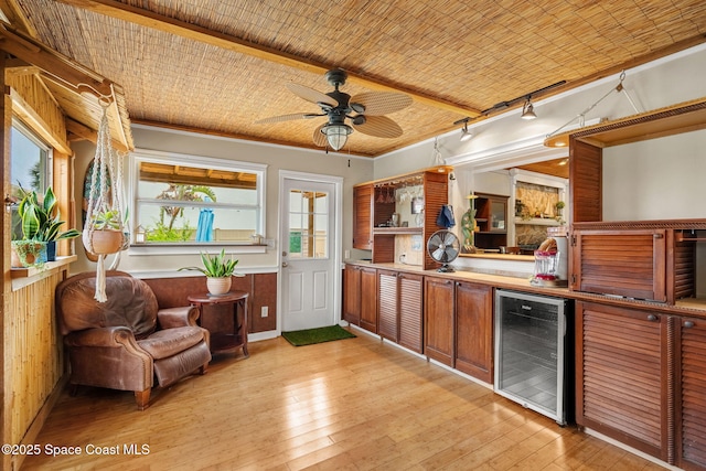 420 Tortoise View Cir, Satellite Beach, FL 32937 - kitchen with beverage cooler, ceiling fan, light wood-style flooring, brown cabinets, and light countertops