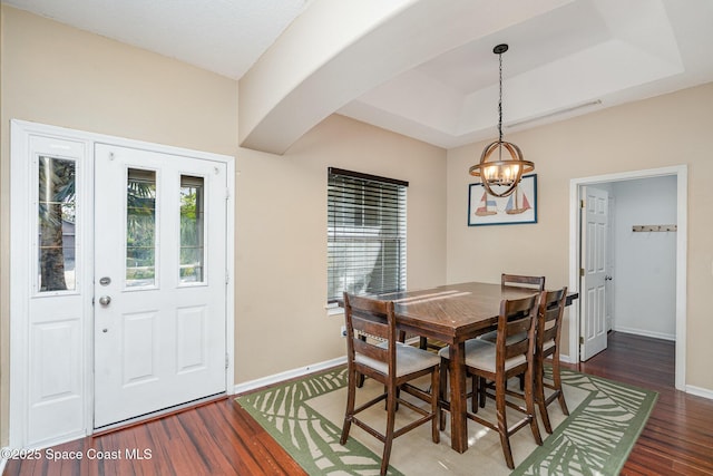 2871 Fontainebleau Ave SE, Palm Bay, FL 32909 - dining area with a chandelier, wood finished floors, baseboards, a tray ceiling, and arched walkways