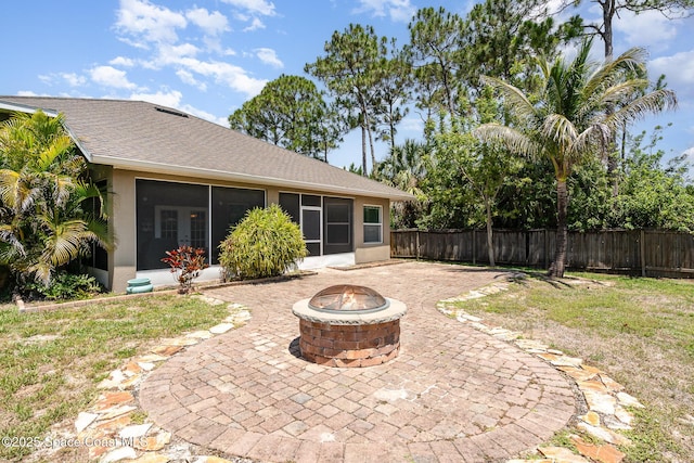 2871 Fontainebleau Ave SE, Palm Bay, FL 32909 - back of house with a sunroom, a fire pit, a patio, a fenced backyard, and a shingled roof