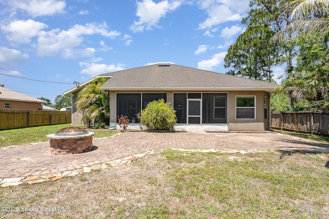2871 Fontainebleau Ave SE, Palm Bay, FL 32909 - rear view of property featuring a fire pit, a sunroom, a patio, roof with shingles, and stucco siding