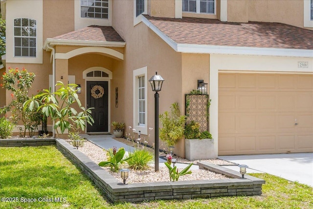 2508 Coral Ridge Cir, Melbourne, FL 32935 - view of exterior entry with stucco siding, a shingled roof, and an attached garage