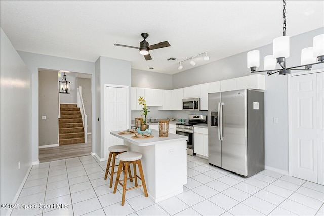 2508 Coral Ridge Cir, Melbourne, FL 32935 - kitchen featuring stainless steel appliances, a chandelier, light countertops, a kitchen bar, and light tile patterned flooring
