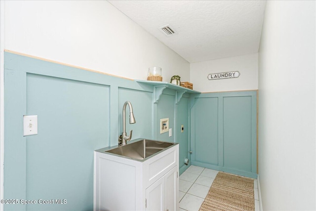 2508 Coral Ridge Cir, Melbourne, FL 32935 - laundry room featuring washer hookup, a textured ceiling, light tile patterned flooring, and a decorative wall