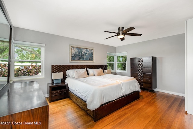 118 S Indian Cir, Cocoa, FL 32922 - bedroom featuring multiple windows, hardwood / wood-style flooring, baseboards, and a ceiling fan