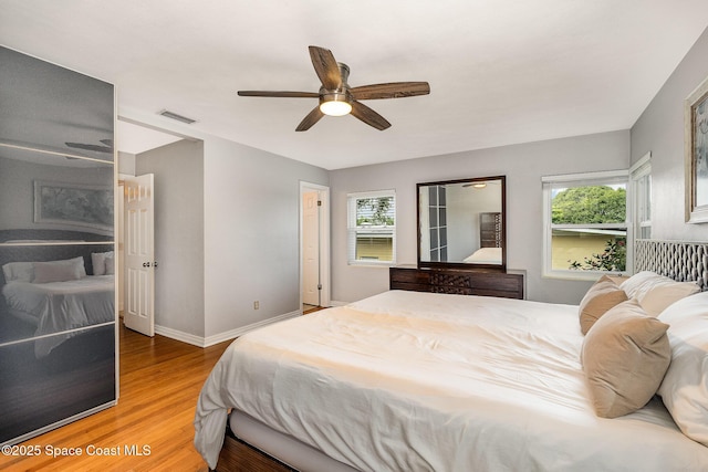 118 S Indian Cir, Cocoa, FL 32922 - bedroom featuring multiple windows, wood finished floors, baseboards, and ceiling fan