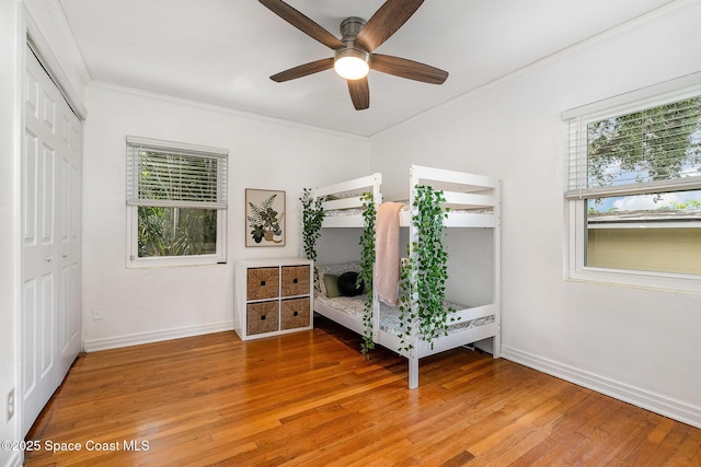 118 S Indian Cir, Cocoa, FL 32922 - bedroom featuring crown molding, baseboards, light wood-style flooring, a closet, and ceiling fan