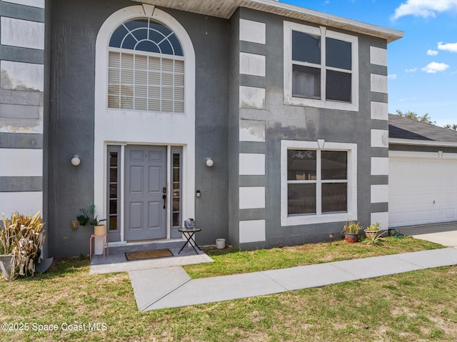 1889 Nanton St NW, Palm Bay, FL 32907 - view of front of house with stucco siding, a garage, and a front lawn