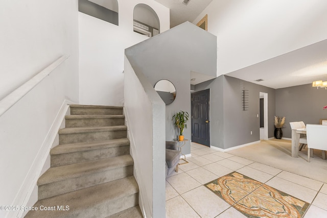 1889 Nanton St NW, Palm Bay, FL 32907 - stairs with tile patterned floors, a chandelier, baseboards, and a high ceiling