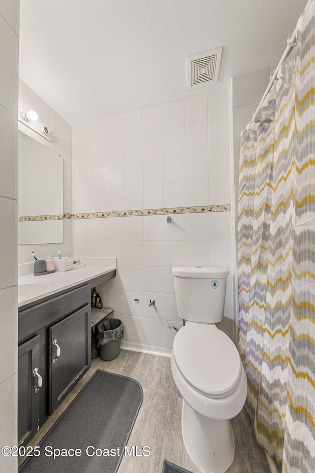 1889 Nanton St NW, Palm Bay, FL 32907 - full bath with vanity, toilet, wood finished floors, tile walls, and a shower with shower curtain
