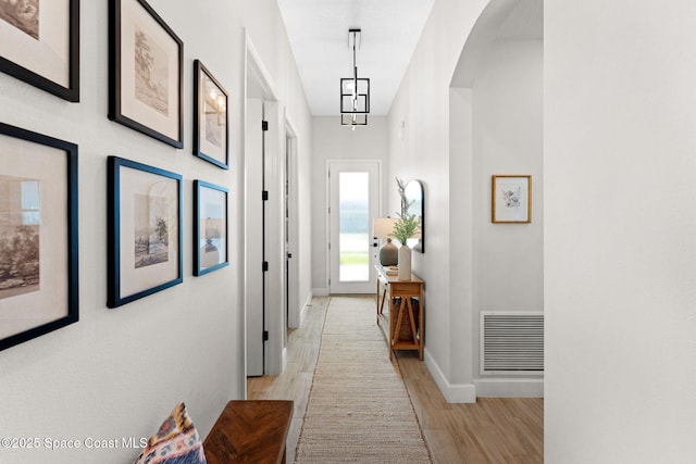 3015 Blazing Star Dr, Melbourne, FL 32940 - hall featuring baseboards, light wood-type flooring, and arched walkways
