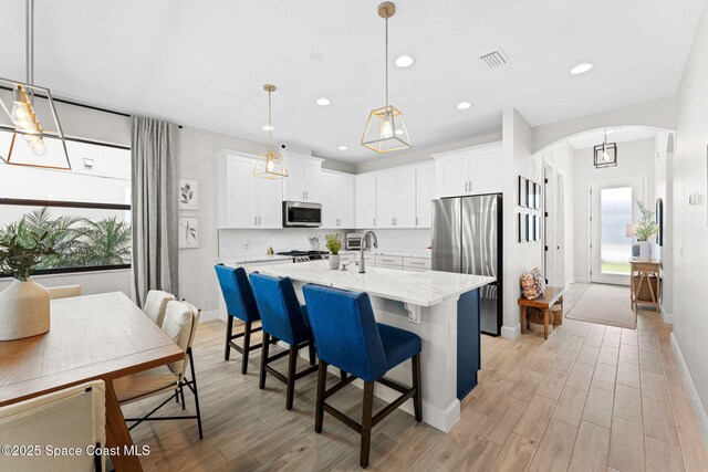 3015 Blazing Star Dr, Melbourne, FL 32940 - kitchen with appliances with stainless steel finishes, arched walkways, light wood-style floors, baseboards, and recessed lighting