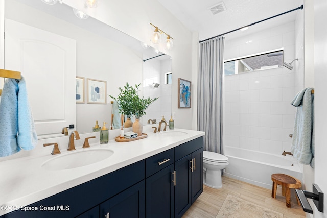 3015 Blazing Star Dr, Melbourne, FL 32940 - bathroom featuring double vanity, toilet, shower / bathtub combination with curtain, and wood finished floors