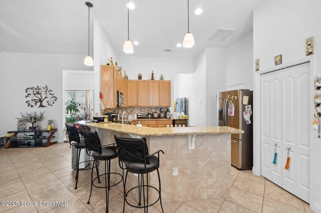 3385 Soft Breeze Cir, Melbourne, FL 32904 - kitchen with stainless steel appliances, a peninsula, light tile patterned flooring, light stone counters, and recessed lighting