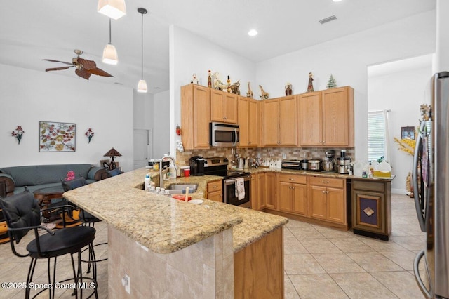 3385 Soft Breeze Cir, Melbourne, FL 32904 - kitchen with stainless steel appliances, a peninsula, open floor plan, a sink, and backsplash