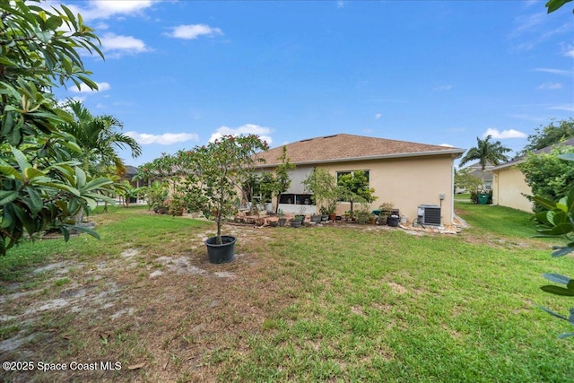 3385 Soft Breeze Cir, Melbourne, FL 32904 - back of property with central AC unit, a lawn, and stucco siding